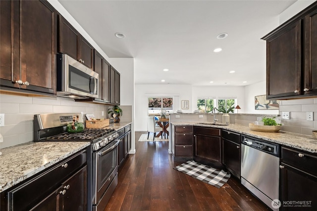 31 157th Ln SE, Bothell, WA 98012 - kitchen featuring stainless steel appliances, dark wood-type flooring, light stone counters, dark brown cabinets, and backsplash