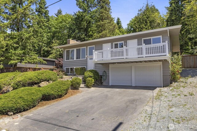 21240 15th Ave S, Des Moines, WA 98198 - view of front of house with a balcony, a garage, asphalt driveway, and a chimney