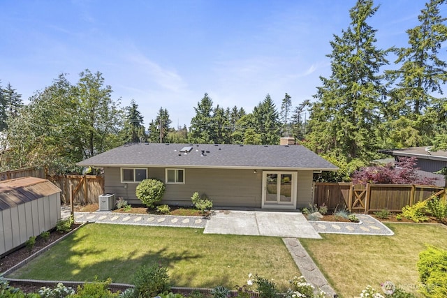 21240 15th Ave S, Des Moines, WA 98198 - back of property with a patio area, a fenced backyard, a shed, a chimney, and a shingled roof