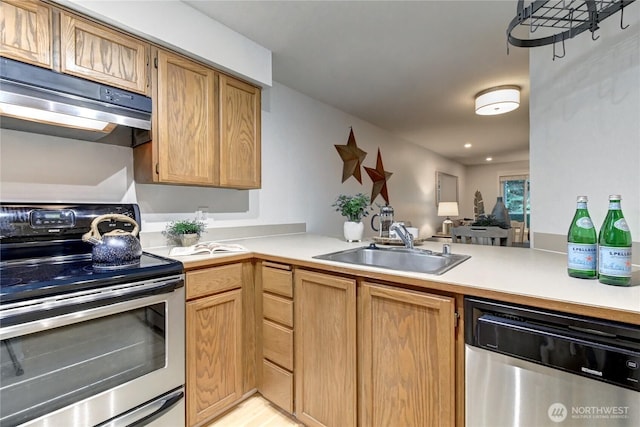 15732 NE 70th Ct, Redmond, WA 98052 - kitchen with appliances with stainless steel finishes, under cabinet range hood, light countertops, a peninsula, and recessed lighting