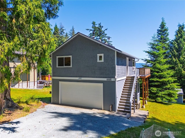 7773 Hideaway Ln, Anacortes, WA 98221 - view of front facade with stairway, a front lawn, gravel driveway, and a garage