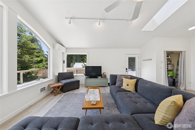 7773 Hideaway Ln, Anacortes, WA 98221 - living area featuring rail lighting, light wood finished floors, a skylight, and ceiling fan