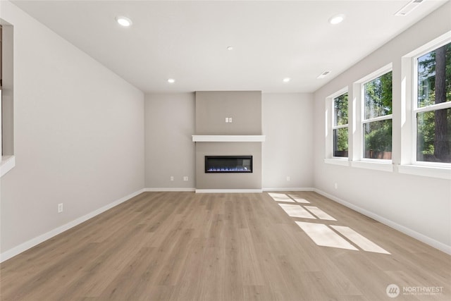 4043 98th Avenue Ct E Unit 24, Edgewood, WA 98371 - unfurnished living room featuring light wood-style flooring, a glass covered fireplace, and recessed lighting