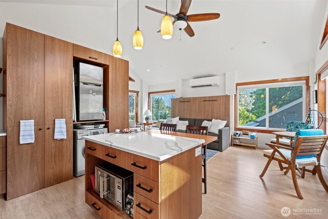 231 Benton, Leavenworth, WA 98826 - kitchen with a wall mounted air conditioner, brown cabinets, healthy amount of natural light, a kitchen bar, and high vaulted ceiling