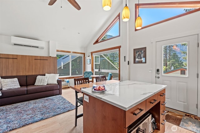 231 Benton, Leavenworth, WA 98826 - kitchen with a wall unit AC, high vaulted ceiling, a ceiling fan, light wood-style floors, and a kitchen island
