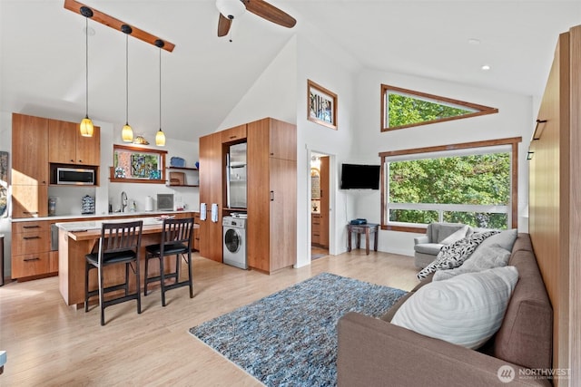 231 Benton, Leavenworth, WA 98826 - living area featuring washer / clothes dryer, high vaulted ceiling, ceiling fan, and light wood-type flooring
