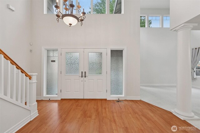 3301 Monterey Ct NE, Renton, WA 98056 - foyer featuring a towering ceiling, stairs, decorative columns, wood finished floors, and a chandelier