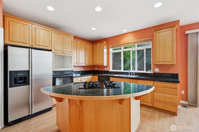 3301 Monterey Ct NE, Renton, WA 98056 - kitchen featuring black appliances, light brown cabinetry, light wood-type flooring, a kitchen breakfast bar, and recessed lighting