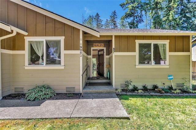 19802 69th Avenue Ct E, Spanaway, WA 98387 - view of exterior entry featuring board and batten siding, a yard, crawl space, and a shingled roof