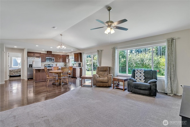 19802 69th Avenue Ct E, Spanaway, WA 98387 - living area featuring vaulted ceiling, dark carpet, ceiling fan, plenty of natural light, and a chandelier