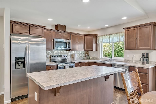 19802 69th Avenue Ct E, Spanaway, WA 98387 - kitchen featuring appliances with stainless steel finishes, wood finished floors, a breakfast bar area, light countertops, and a kitchen island