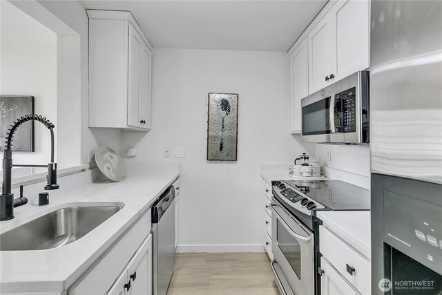 1835 S 286th Ln Unit R201, Federal Way, WA 98003 - kitchen with stainless steel appliances, white cabinetry, light wood-style flooring, and light stone countertops