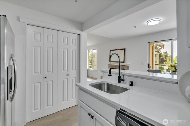 1835 S 286th Ln Unit R201, Federal Way, WA 98003 - kitchen featuring stainless steel refrigerator with ice dispenser, dishwasher, light wood-style flooring, white cabinets, and light stone counters