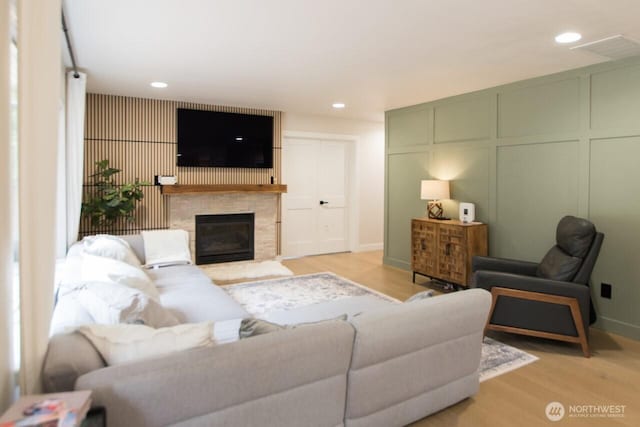 903 198th Ave E, Lake Tapps, WA 98391 - living area featuring light wood-type flooring, a fireplace, recessed lighting, and a decorative wall