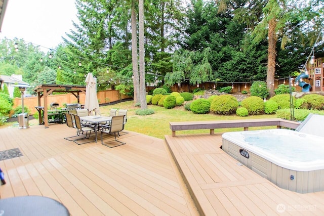 903 198th Ave E, Lake Tapps, WA 98391 - wooden terrace with an outdoor hot tub, outdoor dining space, a fenced backyard, and view of wooded area