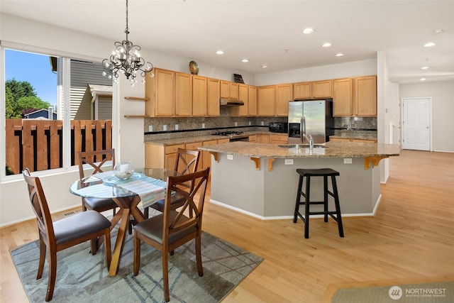 21609 46th Pl S Unit 95, Kent, WA 98032 - kitchen with stainless steel refrigerator with ice dispenser, under cabinet range hood, light brown cabinets, backsplash, and light wood-style floors