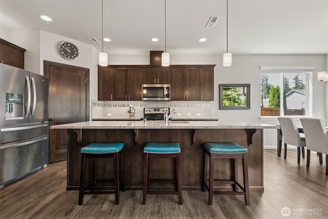 20122 18th Avenue Ct E, Spanaway, WA 98387 - kitchen featuring stainless steel appliances, dark wood finished floors, dark brown cabinets, decorative backsplash, and recessed lighting