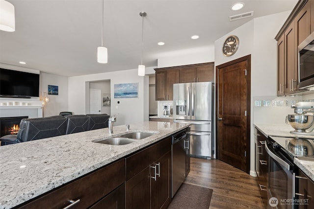 20122 18th Avenue Ct E, Spanaway, WA 98387 - kitchen featuring stainless steel appliances, open floor plan, light stone countertops, dark wood-style flooring, and decorative light fixtures