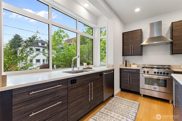 201 20th Ave E, Seattle, WA 98112 - kitchen with wall chimney range hood, stainless steel appliances, dark brown cabinetry, modern cabinets, and recessed lighting