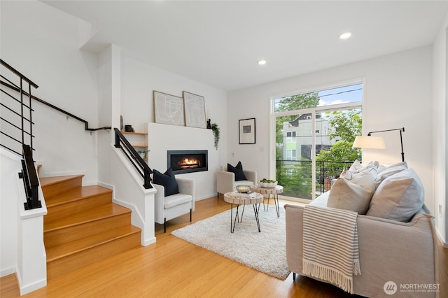 201 20th Ave E, Seattle, WA 98112 - living room featuring stairs, a glass covered fireplace, wood finished floors, and recessed lighting