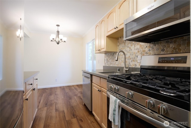 5029 84th St SW Unit 301, Mukilteo, WA 98275 - kitchen with stainless steel appliances, light brown cabinetry, a chandelier, crown molding, and dark wood-style floors