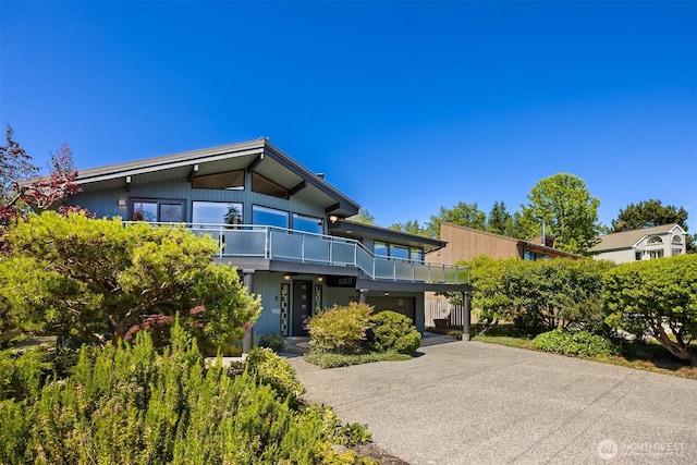 9882 Manitou Beach Dr NE, Bainbridge Island, WA 98110 - contemporary house featuring a balcony, driveway, and a garage