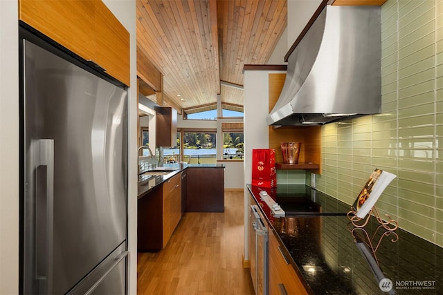 9882 Manitou Beach Dr NE, Bainbridge Island, WA 98110 - kitchen with stainless steel refrigerator, ventilation hood, light wood-style floors, vaulted ceiling, and tasteful backsplash