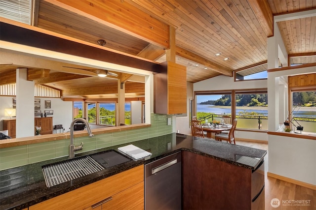 9882 Manitou Beach Dr NE, Bainbridge Island, WA 98110 - kitchen featuring stainless steel dishwasher, decorative backsplash, a water view, a peninsula, and light wood finished floors