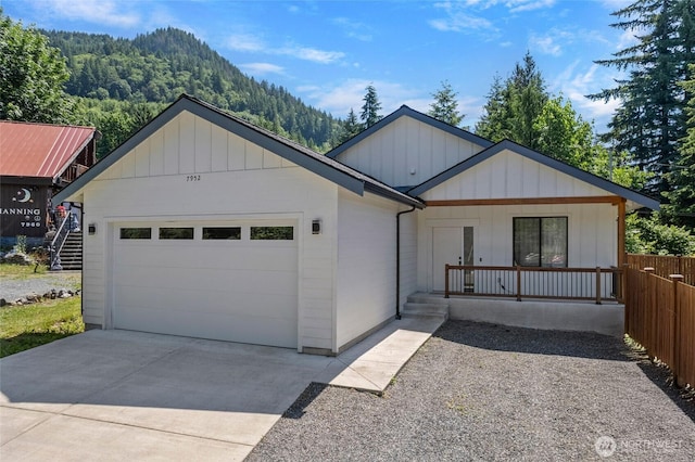 7952 Apache Dr, Maple Falls, WA 98266 - view of front of house with concrete driveway, a garage, covered porch, and a forest view