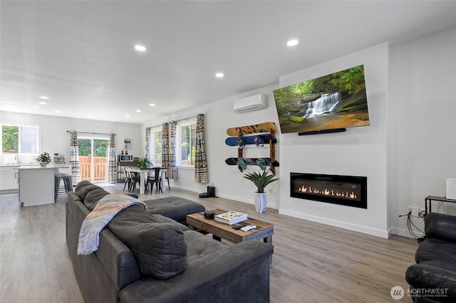 7952 Apache Dr, Maple Falls, WA 98266 - living area featuring a wall mounted air conditioner, recessed lighting, light wood-style floors, and a glass covered fireplace