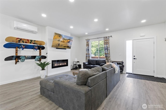 7952 Apache Dr, Maple Falls, WA 98266 - living area featuring a wall mounted AC, wood finished floors, recessed lighting, and a glass covered fireplace