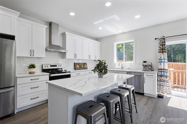 7952 Apache Dr, Maple Falls, WA 98266 - kitchen featuring wall chimney exhaust hood, stainless steel appliances, healthy amount of natural light, dark wood-style floors, and recessed lighting