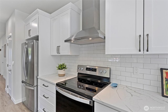7952 Apache Dr, Maple Falls, WA 98266 - kitchen featuring electric stove, wall chimney range hood, freestanding refrigerator, light stone counters, and white cabinets