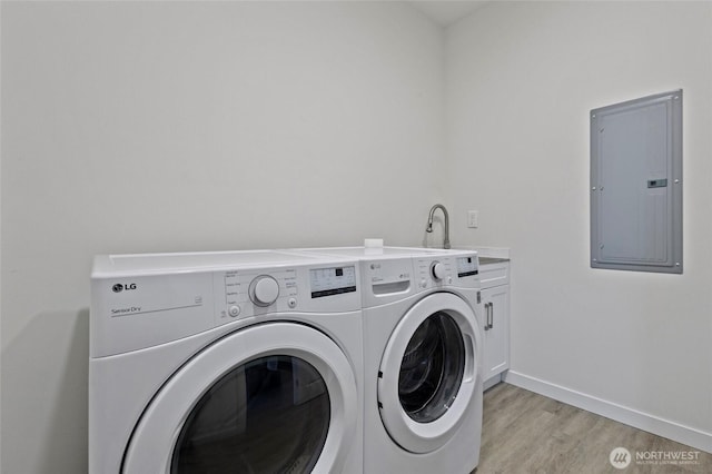7952 Apache Dr, Maple Falls, WA 98266 - laundry area with electric panel, washer and clothes dryer, cabinet space, and light wood-type flooring