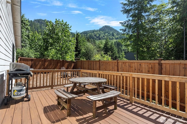 7952 Apache Dr, Maple Falls, WA 98266 - wooden deck with a fenced backyard, a wooded view, outdoor dining area, and a grill