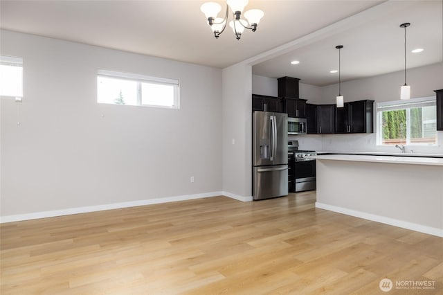 128 N Trail Rd, Sedro Woolley, WA 98284 - kitchen featuring appliances with stainless steel finishes, a chandelier, light countertops, dark cabinets, and light wood-style flooring