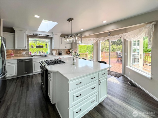 677 Schultz Dr, Bellingham, WA 98226 - kitchen featuring dishwasher, a skylight, black gas stove, white cabinetry, and recessed lighting