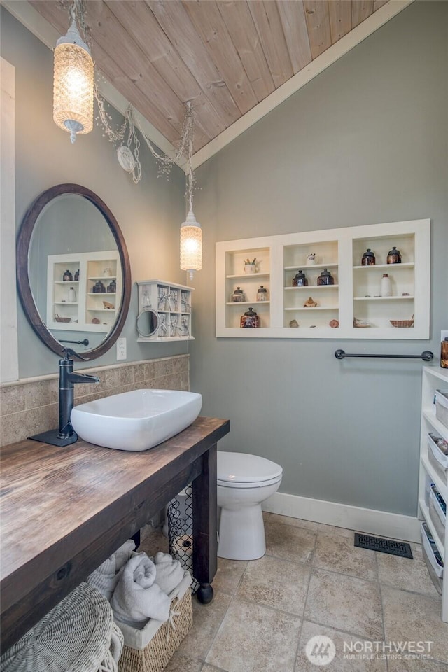 604 Ocean Shores Blvd SW, Ocean Shores, WA 98569 - bathroom featuring lofted ceiling, wooden ceiling, vanity, crown molding, and stone tile floors