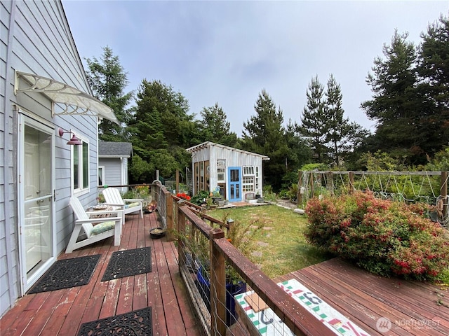604 Ocean Shores Blvd SW, Ocean Shores, WA 98569 - wooden deck featuring an outdoor structure, a lawn, and view of wooded area