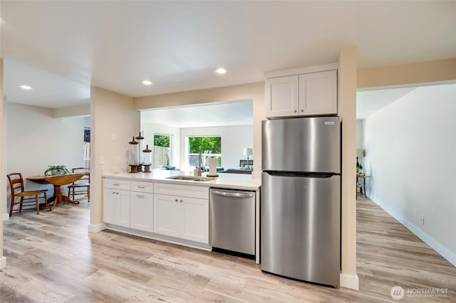 6015 Dexter Ave Unit A/B, Everett, WA 98203 - kitchen with appliances with stainless steel finishes, light wood-style flooring, white cabinets, light countertops, and recessed lighting
