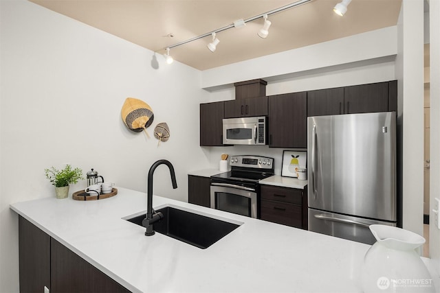 300 110th Ave NE Unit 303, Bellevue, WA 98004 - kitchen with appliances with stainless steel finishes, rail lighting, a peninsula, and light countertops