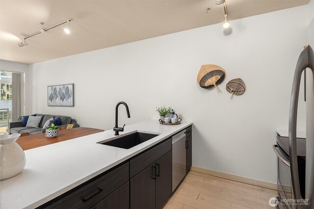 300 110th Ave NE Unit 303, Bellevue, WA 98004 - kitchen with track lighting, appliances with stainless steel finishes, light wood-style flooring, light countertops, and open floor plan
