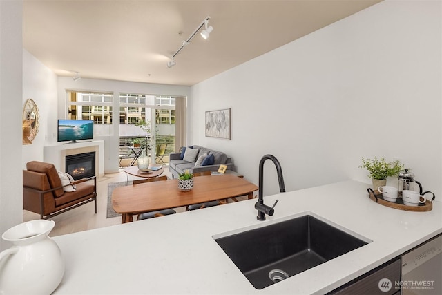 300 110th Ave NE Unit 303, Bellevue, WA 98004 - kitchen with open floor plan, a glass covered fireplace, rail lighting, light countertops, and dishwasher