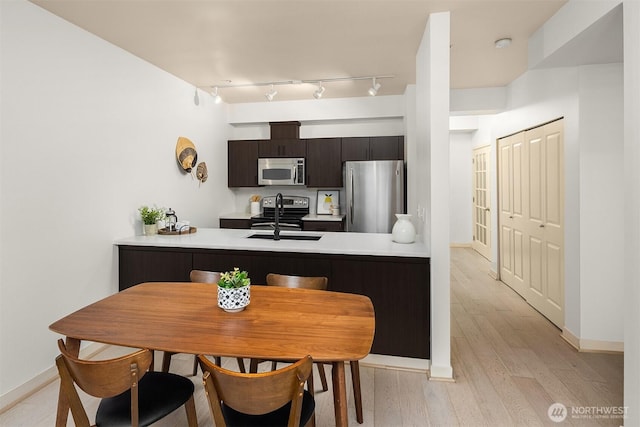 300 110th Ave NE Unit 303, Bellevue, WA 98004 - kitchen with appliances with stainless steel finishes, light countertops, a peninsula, and light wood finished floors