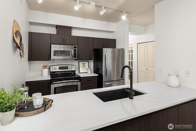 300 110th Ave NE Unit 303, Bellevue, WA 98004 - kitchen featuring appliances with stainless steel finishes, rail lighting, dark brown cabinetry, and light countertops