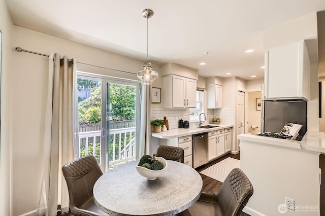 17201 127th Pl NE Unit 101, Woodinville, WA 98072 - kitchen featuring appliances with stainless steel finishes, light countertops, white cabinetry, and tasteful backsplash