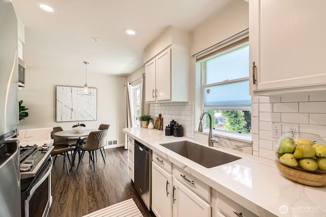 17201 127th Pl NE Unit 101, Woodinville, WA 98072 - kitchen featuring appliances with stainless steel finishes, white cabinetry, healthy amount of natural light, dark wood finished floors, and recessed lighting