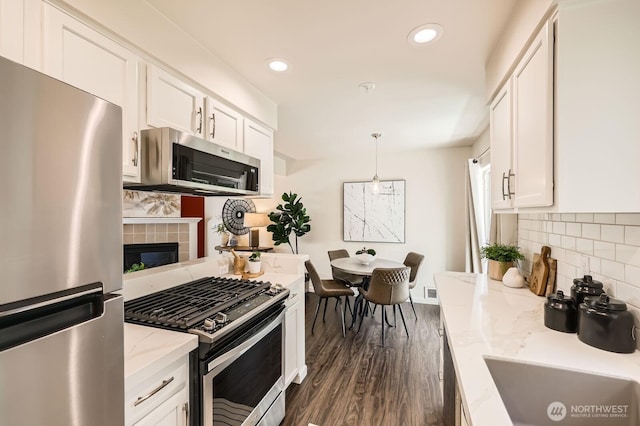 17201 127th Pl NE Unit 101, Woodinville, WA 98072 - kitchen featuring stainless steel appliances, white cabinetry, decorative backsplash, dark wood-type flooring, and recessed lighting