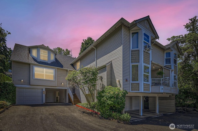 17201 127th Pl NE Unit 101, Woodinville, WA 98072 - townhome / multi-family property with a garage, driveway, stairway, a balcony, and a shingled roof