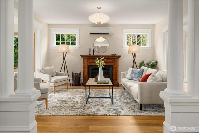 2401 10th Ave W, Seattle, WA 98119 - living area with a wall unit AC, plenty of natural light, wood finished floors, and ornate columns